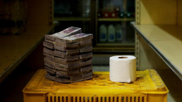 Toilet paper roll next to a pile of bills