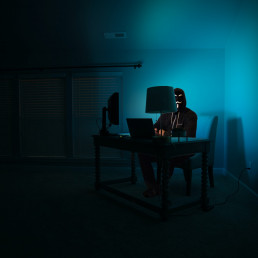 Spoofing - Un hacker est dans la pénombre derrière son ordinateur