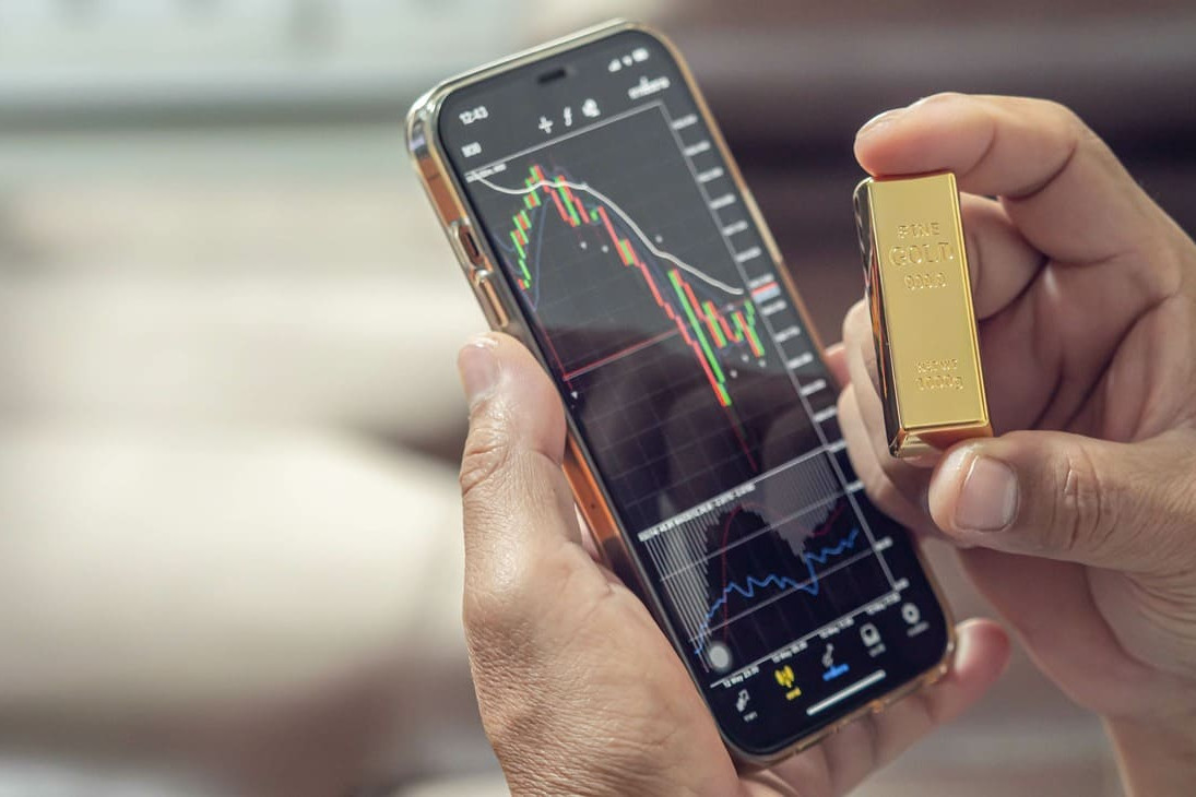 téléphone sur une application de trading montrant le cours or ainsi qu'un lingot