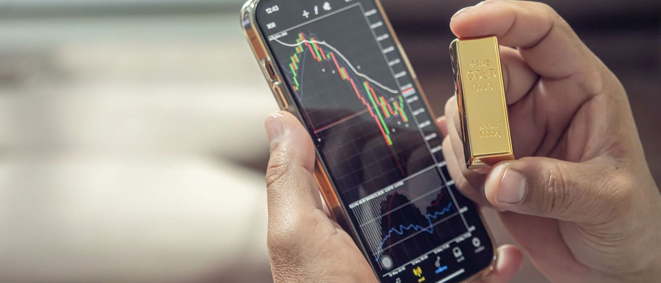 téléphone sur une application de trading montrant le cours or ainsi qu'un lingot