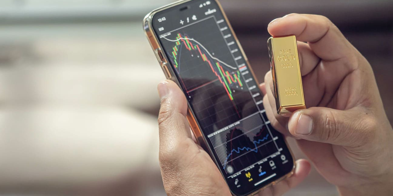 téléphone sur une application de trading montrant le cours or ainsi qu'un lingot
