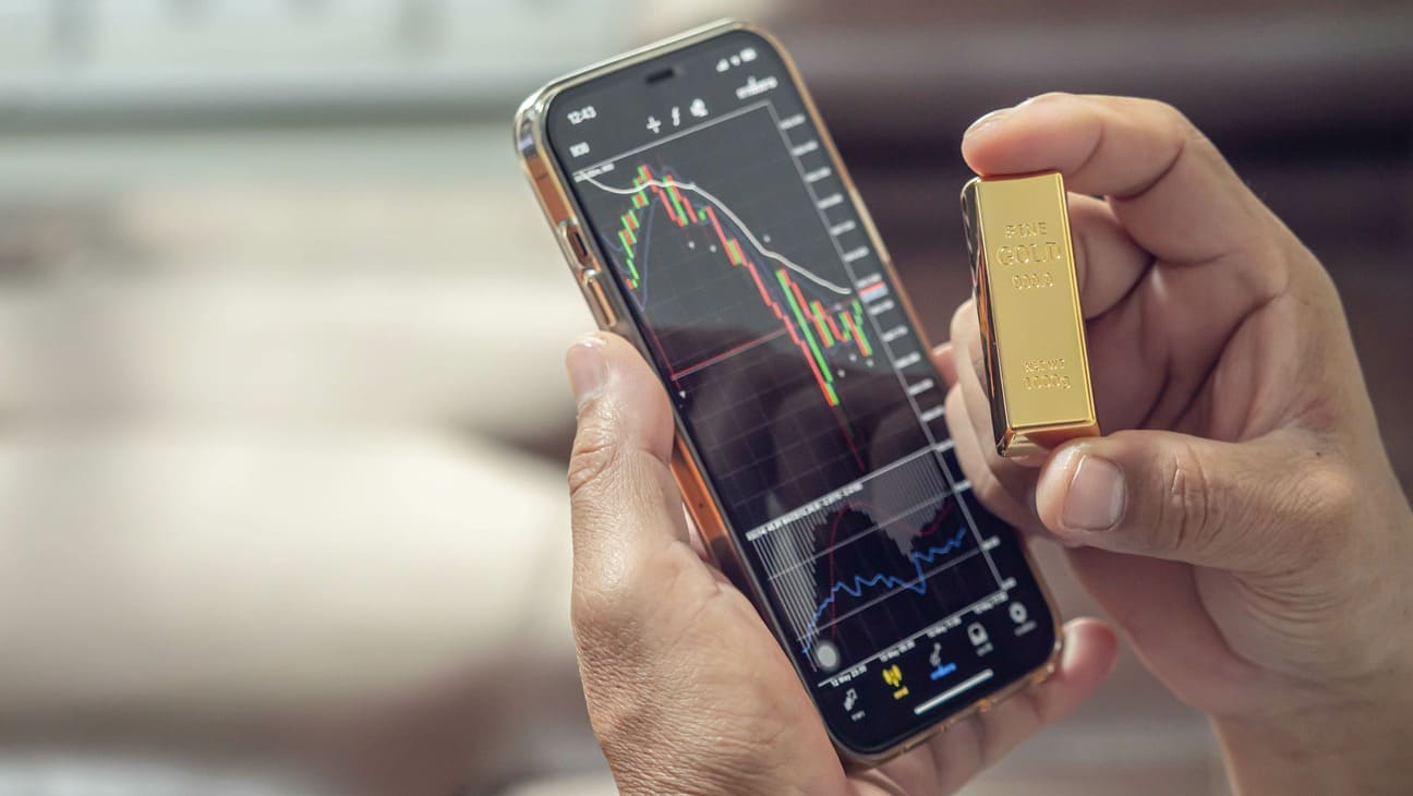 téléphone sur une application de trading montrant le cours or ainsi qu'un lingot