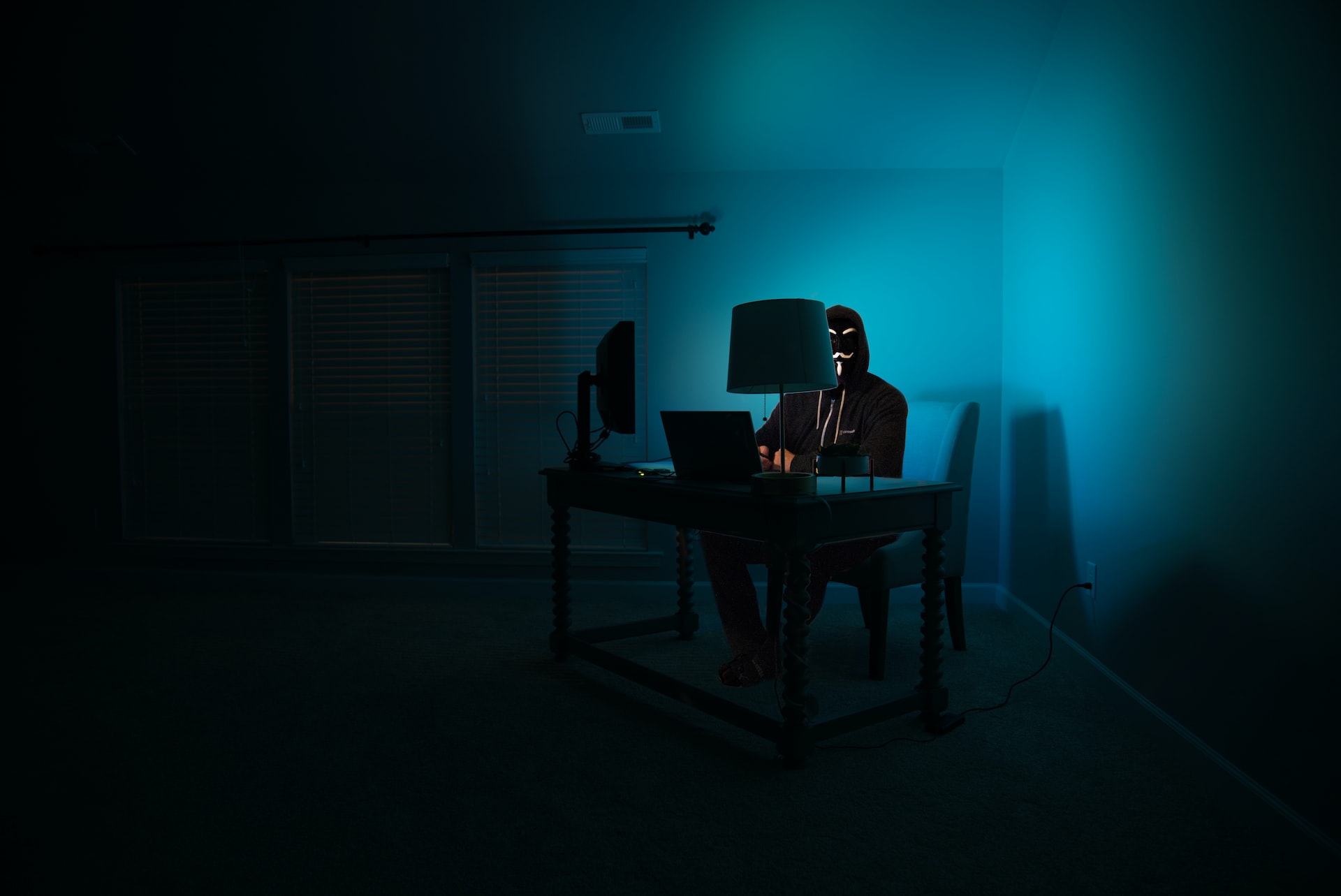 Spoofing - Un hacker est dans la pénombre derrière son ordinateur