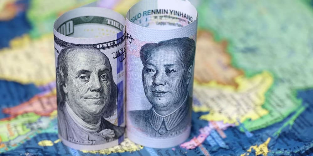 billets de dollar et yuan posés sur une carte du monde - article dédollarisation
