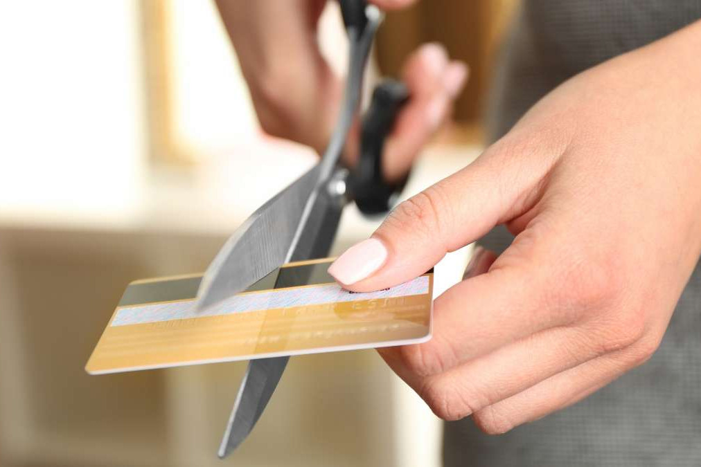 femme coupant une carte bancaire