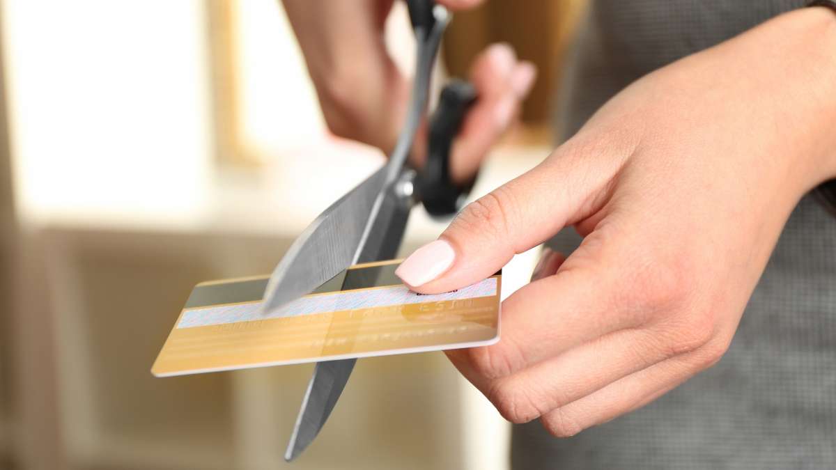 femme coupant une carte bancaire